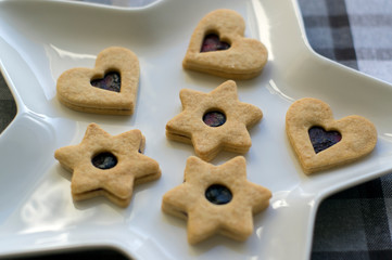 Christmas sweets and cookies made from shortcrust pastry, various shapes filled with marmalade and decorated with chocolate