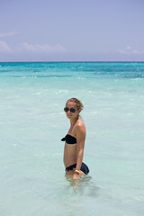 Junge sportliche Frau steht im Wasser in der Karibik