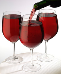 POURING RED WINE INTO THREE GLASSES