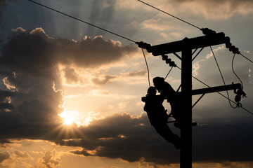 Silhouette, Power lineman maintain high-strength distribution system. The backdrop is a beautiful blue sky. Isolated from background with clipping path.