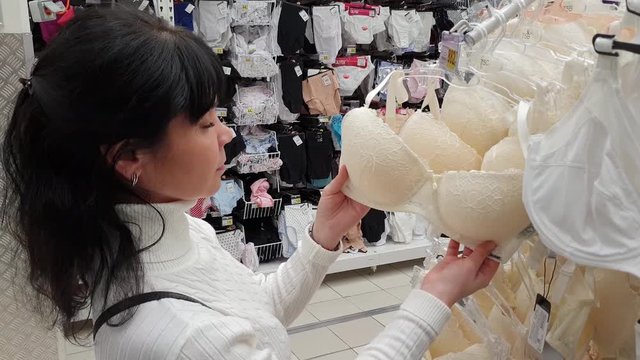 Woman shopping in mall. Choosing underwear, bra.