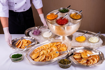 Red caviar, caviar of a pike, sour cream, onions, capers, eggs with pancakes