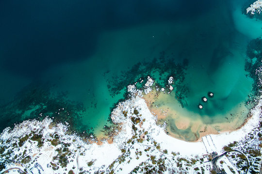Aerial of the ocean and a snow covered beach
