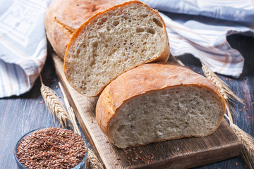 Homemade  freshly baked  bread with flax seeds  on dark wooden b