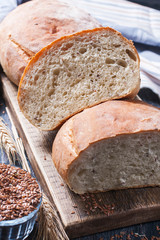 Homemade  freshly baked  bread with flax seeds  on dark wooden b