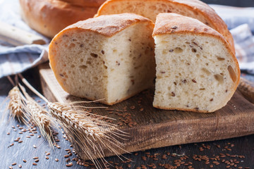 Homemade  freshly baked  bread with flax seeds  on dark wooden b