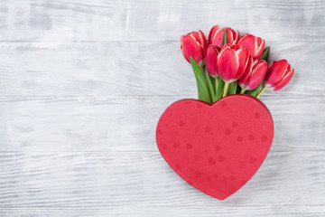 Obraz na płótnie Canvas Red tulip flowers and heart gift box