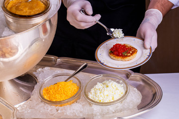 Fritters with boiled protein, red caviar, is served with fennel