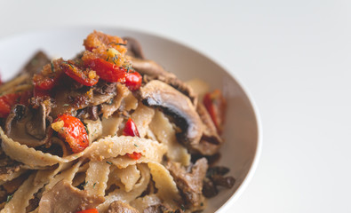 Juicy plate of fresh pasta with mushrooms and tomatoes