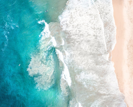 Aerial of beach waves crashing on the shore