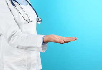 Female doctor offering helping hand on color background, closeup