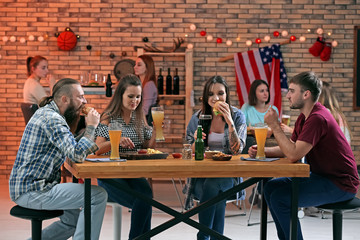 Friends with beer and snacks in sport bar