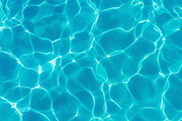 Fototapeta na wymiar Water ripples and pattern on swimming pool surface with sunlight reflection