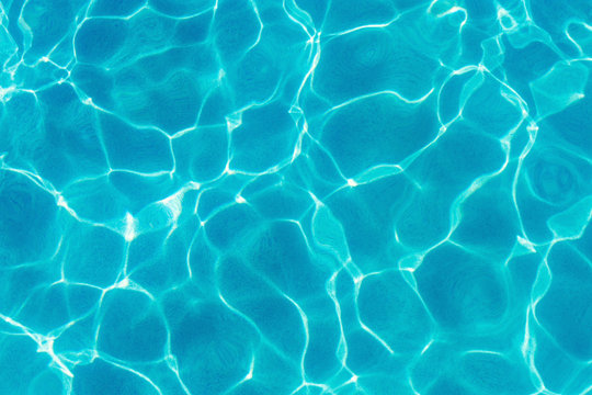Water ripples and pattern on swimming pool surface with sunlight reflection