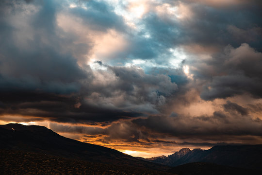 Clouds billowing over mountains during sunset
