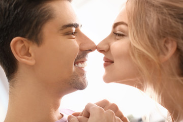 Cute young couple dancing on light background