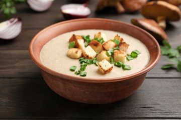 Bowl of fresh homemade mushroom soup on wooden table