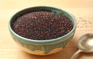 Bowl with black quinoa on wooden table
