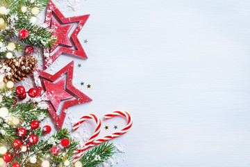 Christmas background with stars, snowy fir branches, cones and bokeh lights. Holiday banner or card.