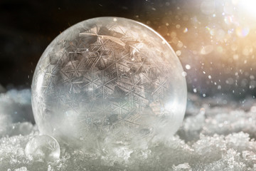 gefrorene Seifenblasen im Schnee mit bokeh und lens flare