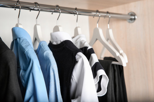 Stylish boy's clothes hanging in wardrobe, closeup