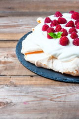 Homemade cake Pavlova with whipped cream and fresh raspberry.