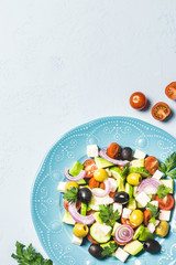 Avocado olives greek salad on blue plate. Top view, space for text.