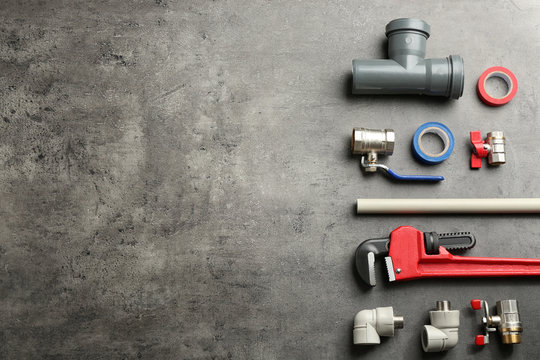 Flat lay composition with plumber's tools and space for text on gray background