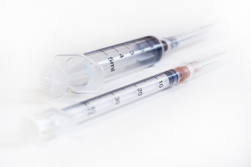 Fototapeta premium Disposable syringe. Plastic insulin syringe. The insulin syringe with the lid open shows sharp needles. Injection medicine. Medical equipment.