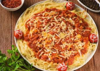 handmade pasta in tomato sauce with spices and vegetables in cheese breaded, decorated with parsley and cherry tomatoes