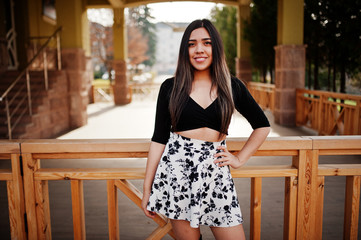 Pretty latino model girl from Ecuador wear on black tops and skirt posed at street.