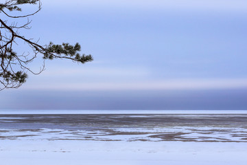 Winter day on snowy shore of Narva Bay. Snow on the ice of the frozen Gulf of Finland. Narva-Joesuu resort town in North-East of Estonia in Ida-Virumaa County. Severe Northern winter and snowy weather