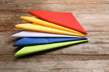 Colorful paper napkins on wooden background. Personal hygiene