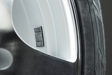 A fragment of the wheel of a car with a balancing weight