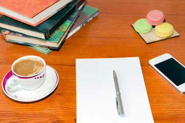 White paper with pen, books, telephone,