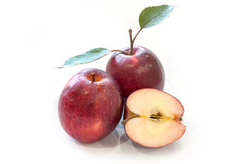 Fresh red apples with leaves isolated on white background