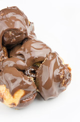 Delicious profiteroles with cream and chocolate glaze isolated