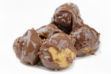Delicious profiteroles with cream and chocolate glaze isolated