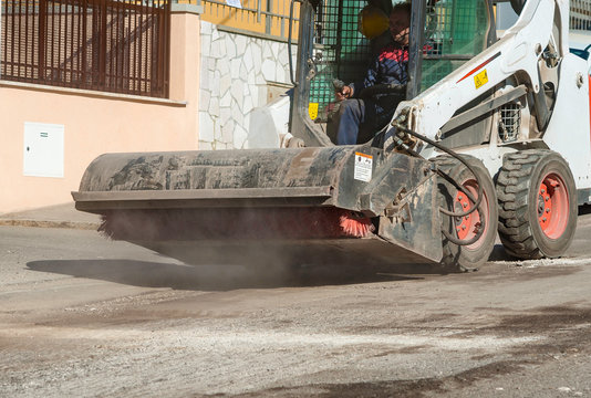 Sweeper attachments mini excavator. The sweeper sweeps, collects and dumps dirt and debris.