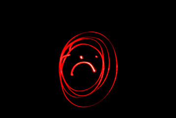 Angry face. Angry emoji face in darkness. Abstract red face silhouette. 