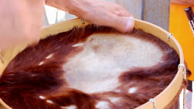 Man playing drums with surface made of animal hair and skin. Music band concert, local band, traditional festival, party celebration event concepts