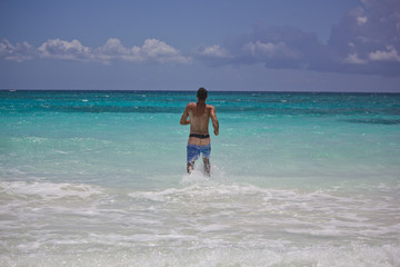 Fototapeta na wymiar Junger Typ in der Karibik mit Badeshorts