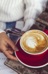 The girl holds a cup of coffee