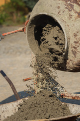 Construction site work with concrete mixer and wheelbarrows