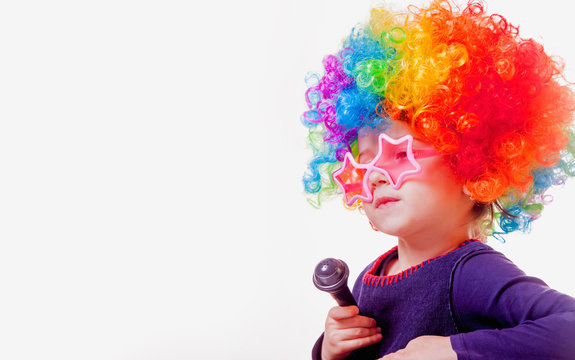 The famous actress. Humorous photo of cute child girl with a microphone (Happy childhood, teaching singing, music, child development concept)