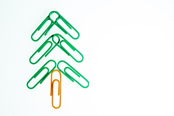 Green christmas tree from color paperclip on white background isolated