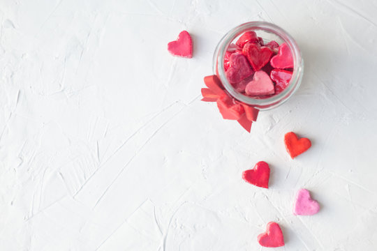 Valentine's day concept. jar with hearts of sweets on a light background, top view