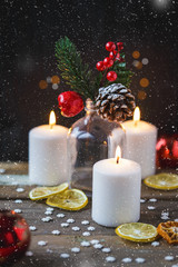 Christmas decorations, burning candles, candy , snowflakes, citrus, spruce on a wooden background. New Year's concept. Postcard