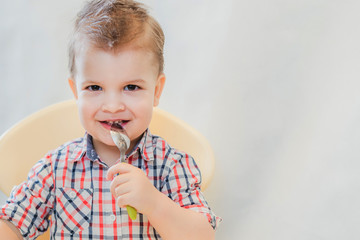 the kid in the kitchen eats milk porridge