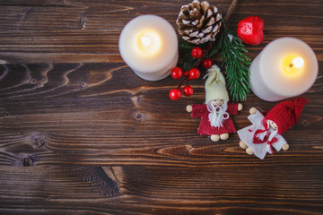 Christmas decorations, burning candles, spruce on a wooden background. New Year's concept. Postcard